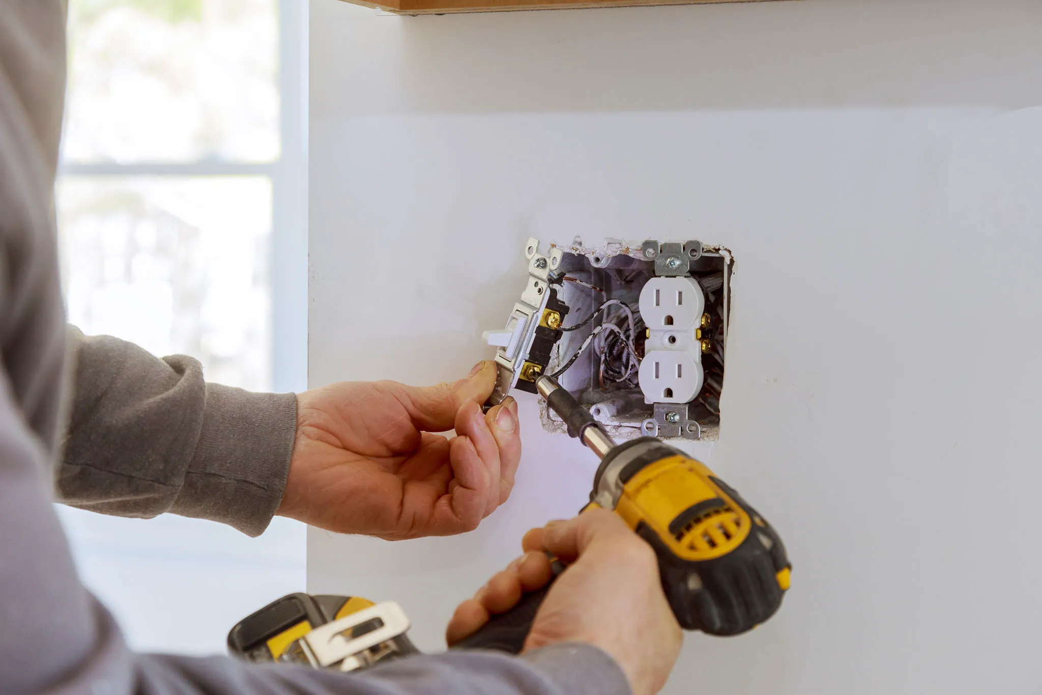 Electrician installs electrical fixtures in home